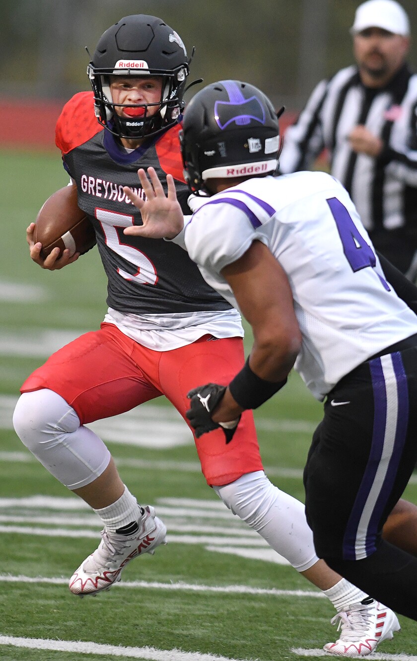 Duluth East quarterback Peyton Witzman (5) stiff arms Cloquet’s Alexander Omenge (4) during a run in the first quarter