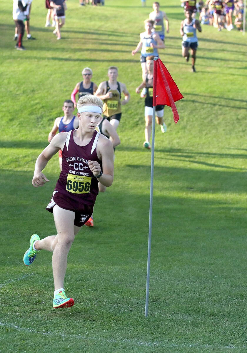 Solon Springs' Dylan Taggart (6956) makes a turn as he leads the pack in the first lap at the John Woodbury Invitational