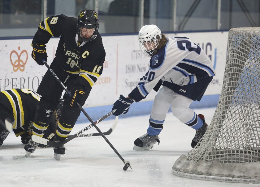Duluth Marshall’s Ilsa Lindaman (19) works the puck behind the net in front of Superior’s Gabryel Olson (20)