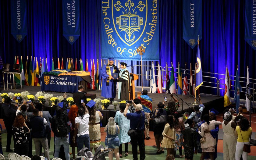 Graduate and college president pose together