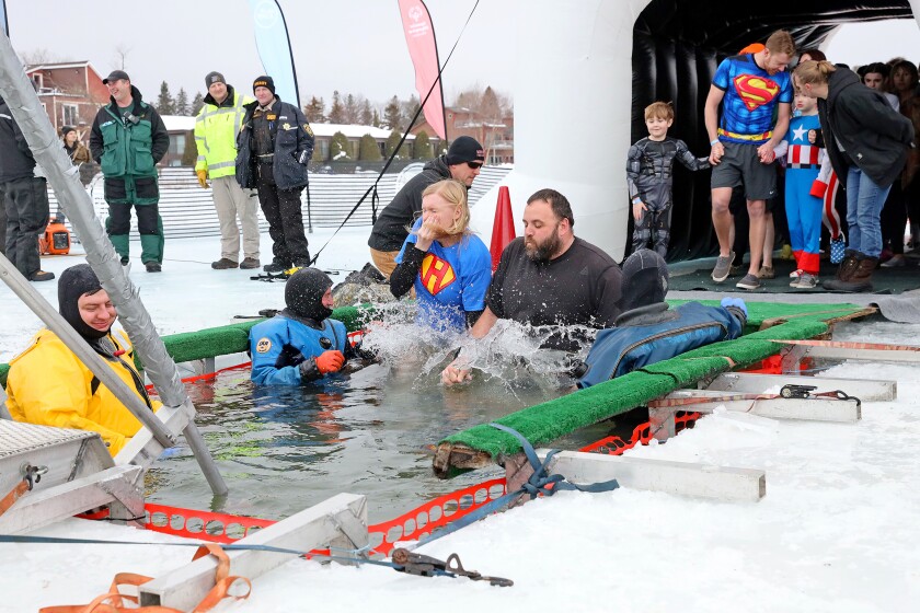 People jump into the water during the Polar Plunge event on Pelican Lake.