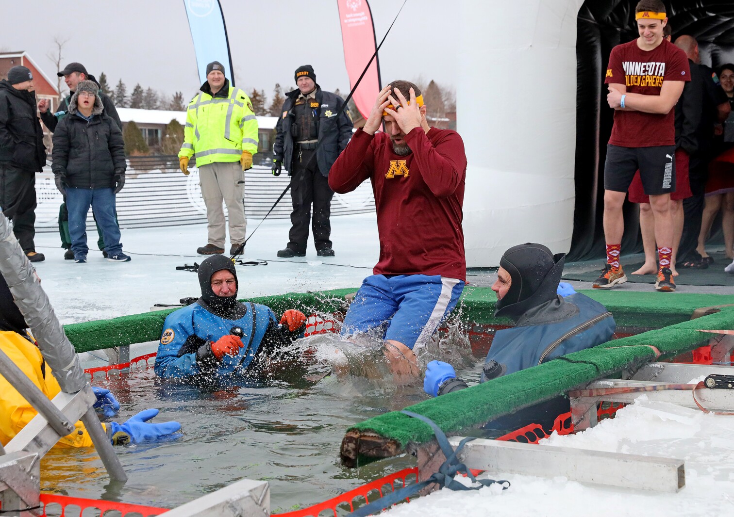 People jump into the water during the Polar Plunge event on Pelican Lake.