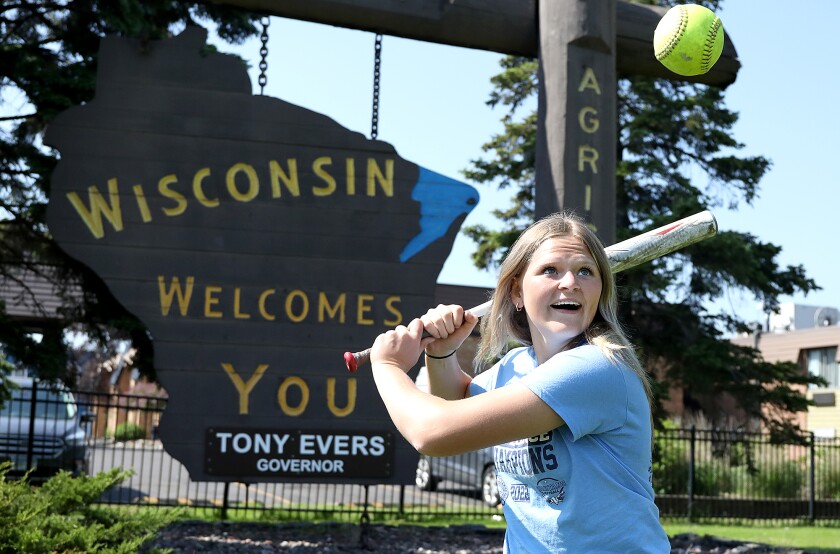Superior’s Emma Raye flashes a big smile as she watches a ball near the Wisconsin Welcomes You sign