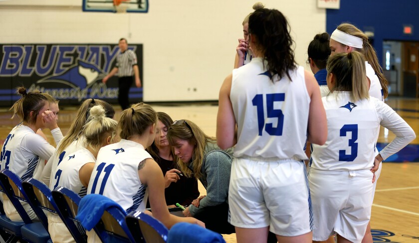 Minnesota West Lady Jays head coach Rosalie Hayenga-Hostikka and assistant coach Avery Van Roekel go over offense with their players during a time-out Saturday against the St. Cloud Tech Cyclones.