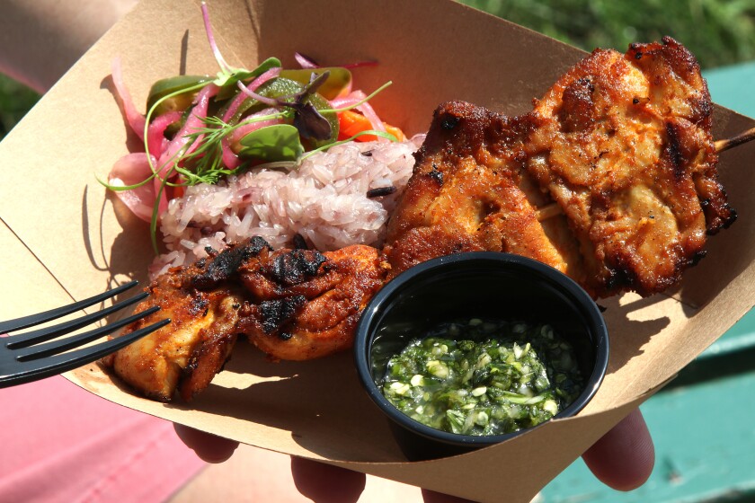 Meat and rice served in a paper bowl.