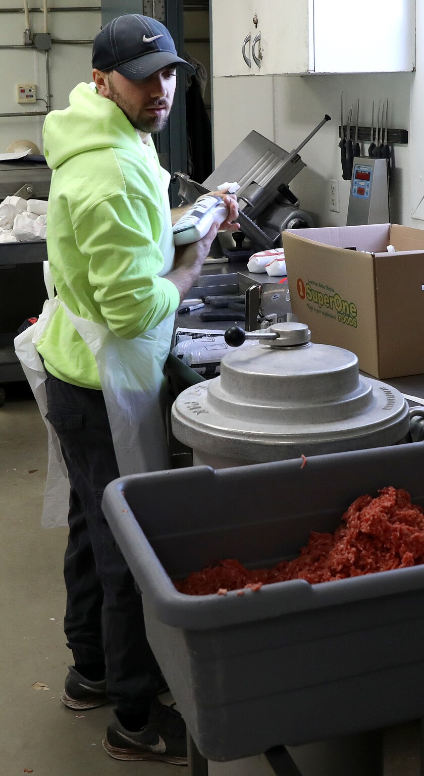 Daniel Litchke looks over at the bin of ground beef as he fills bags for customers at Litchke Farms