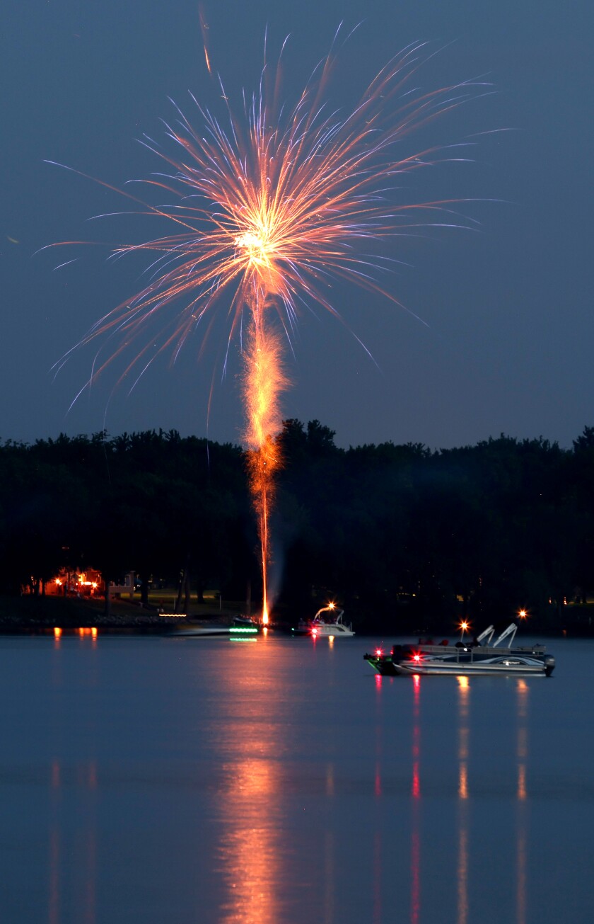 Boaters enjoy the Independence Day fireworks from watercraft on Lake Okabena Monday evening, July 4, 2022.
