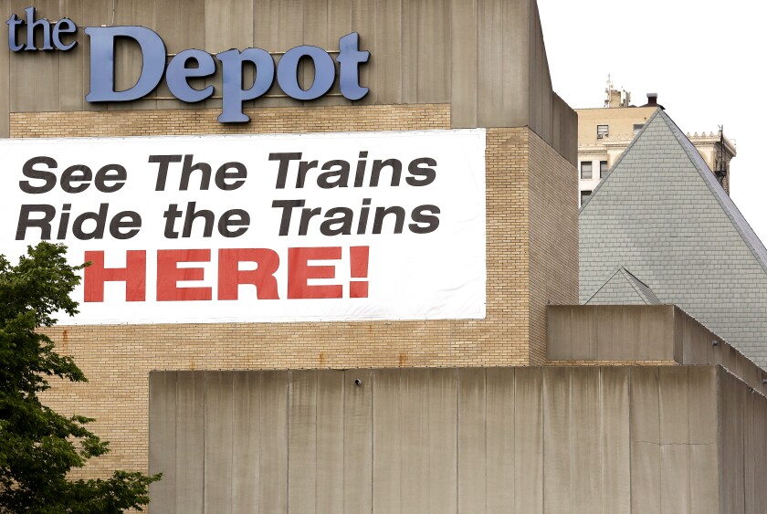 Exterior of Duluth Depot features a large sign reading "See The Trains / Ride the Trains HERE!"