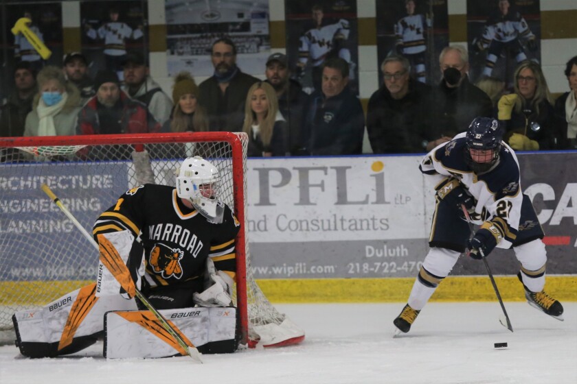 Hermantown's Zam Plante tries to beat Warroad goaltender Hampton Slukynsky.