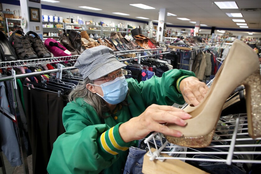 Salvation Army Thrift Store employee Nancy Cox places a pair of high heels on a rack
