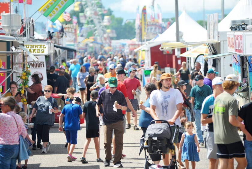 Fairgoers walk through the food area at the fair