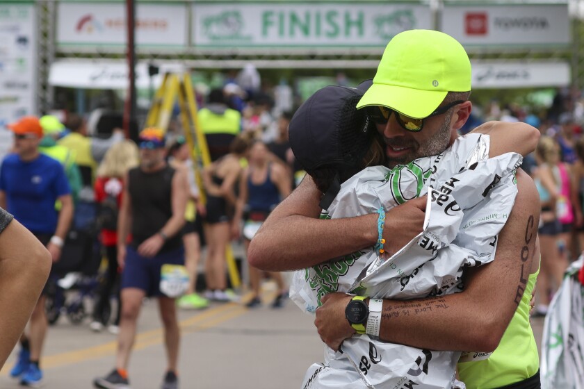 Athletes running and celebrating at the finish line area of Grandma's Marathon