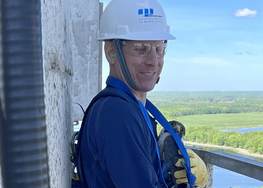 Minnesota Power employee hold adult falcon.