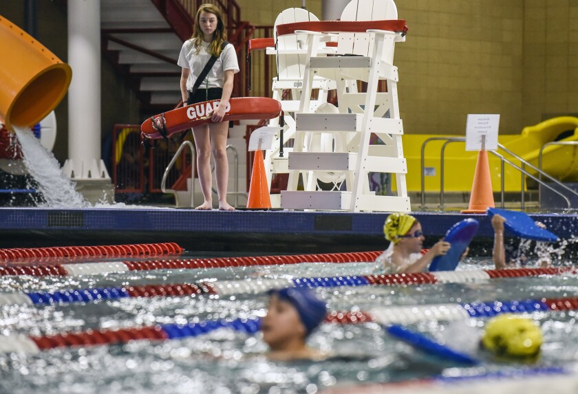 Lifeguard Claire Lepke watches over the swimmers practicing with their kickboards in the lap pool at the Mitchell Indoor Aquatic Center on Thursday afternoon. (Matt Gade / Republic)