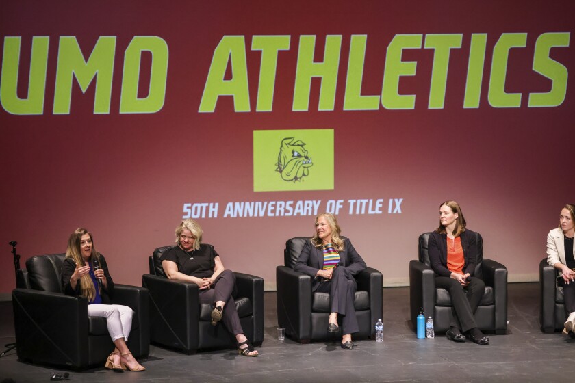 Women participating in live panel on theatre stage