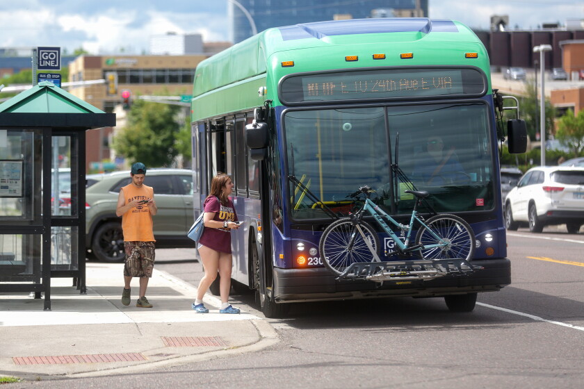 A woman and man boarding a bus.