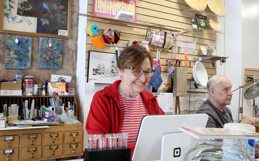 Woman works at register next to a man.