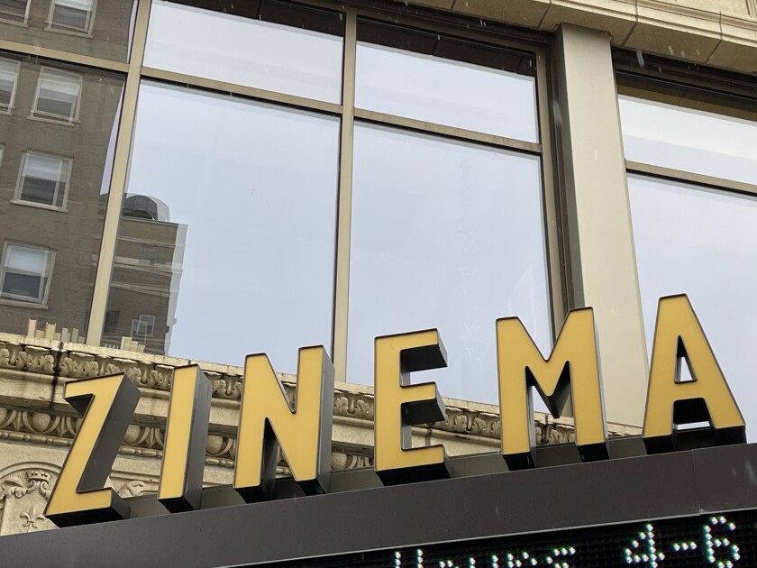 Marquee reading ZINEMA, seen against a reflective glass background.