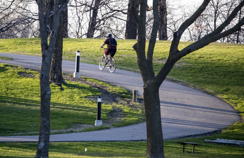 A cyclinst bikes along a pathway at Robbins Island Regional Park during sunset in Willmar on Friday, May 6, 2022.