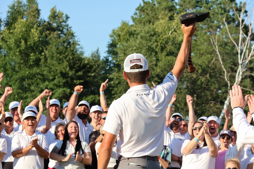 Golfer Michael Brennan holds up the Paul Bunyan Axe Trophy he won as the crowd cheers on Sunday, Aug. 31, 2025, at the close of the PGA Tour Americas CRMC Championship presented by Northern Pacific Center at Cragun's Legacy Courses.