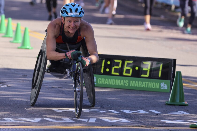 Athletes running and celebrating at the finish line area of Grandma's Marathon