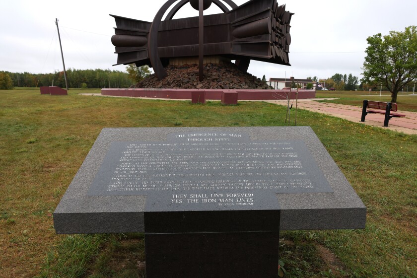 Engraved stone plaque in front of statue