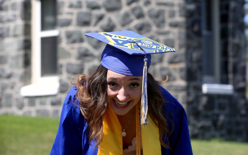 Graduates smiles while showing off her mortarboard