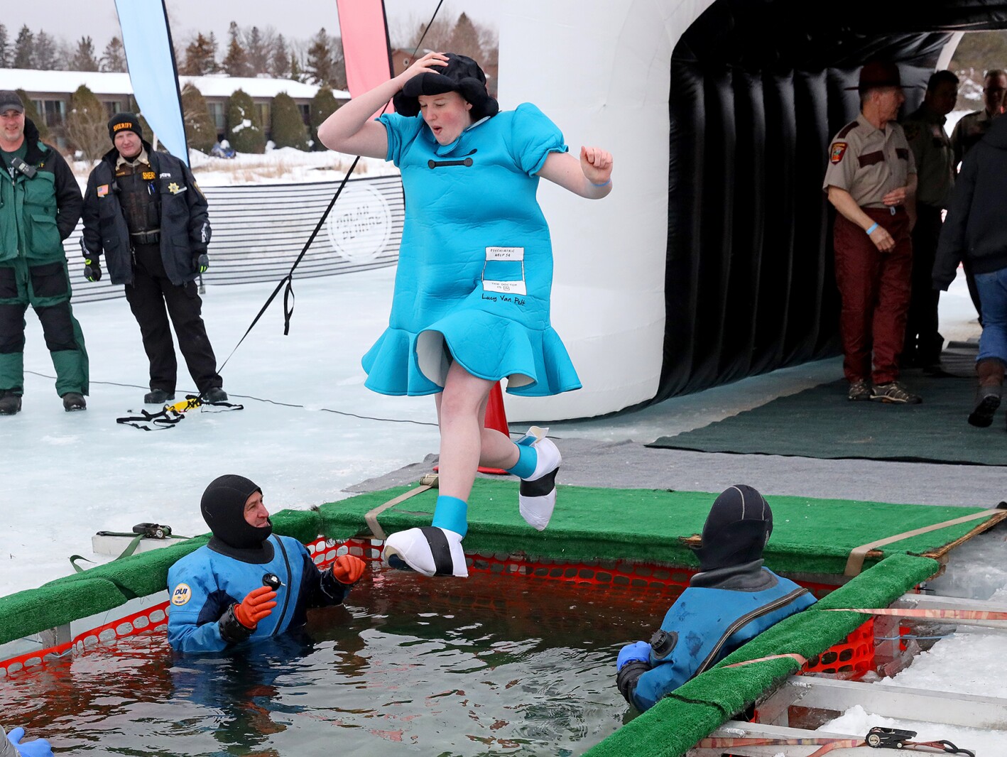 People jump into the water during the Polar Plunge event on Pelican Lake.