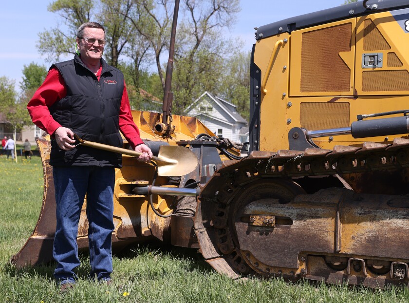 A Worthington JBS official poses with heavy equipment at the groundbreaking for a development of six single-family homes at 2290 East Ave. in Worthington Monday morning.