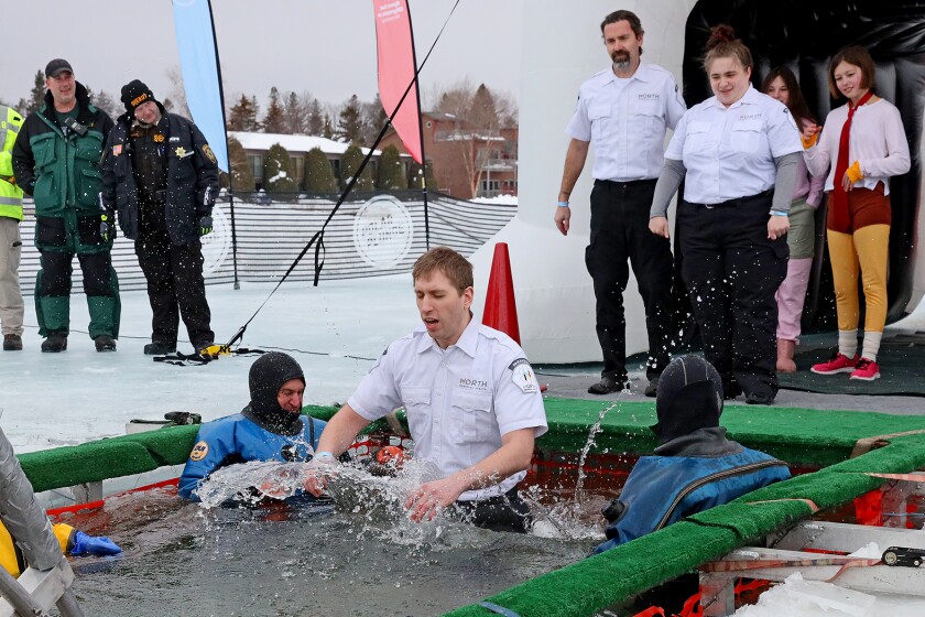 People jump into the water during the Polar Plunge event on Pelican Lake.