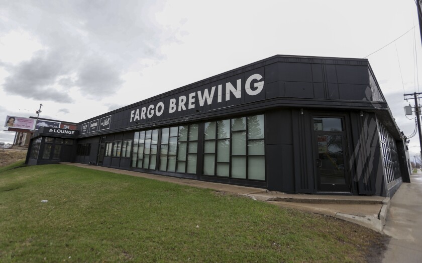 A black, one-story building has white letters painted along the top that read "Fargo Brewing."