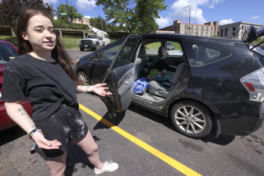 Woman standing by her car.