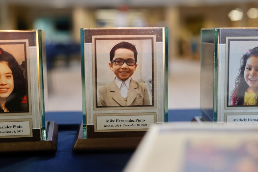 A plaque and candle with a portrait of Mike Hernandez Pinto.