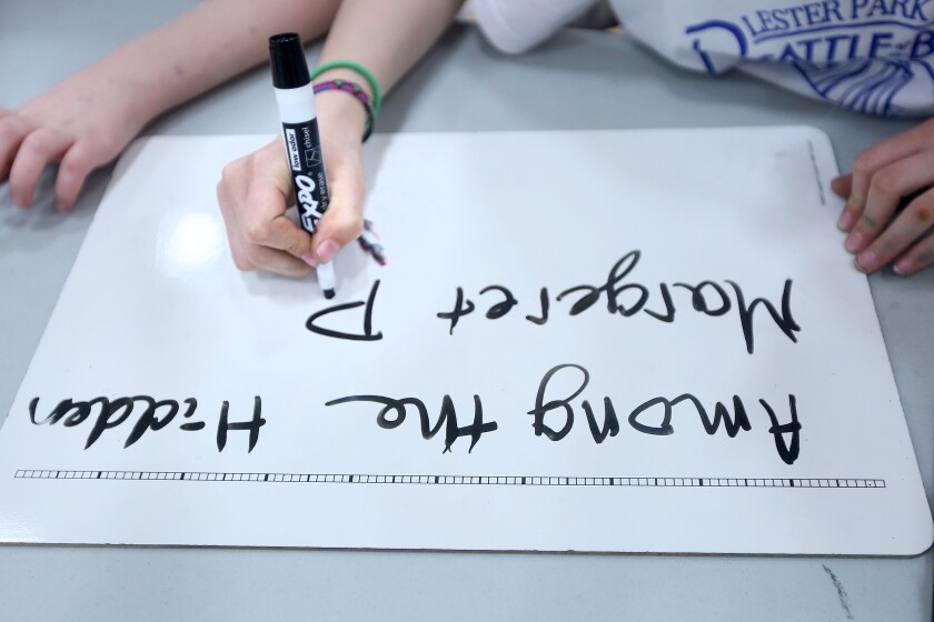 Members of the Magic Narwhals of the Reed team write down the name of the book "Among the Hidden" by Margaret Peterson Haddix as the answer to one of the 20 questions. Bob King / rking@duluthnews.com