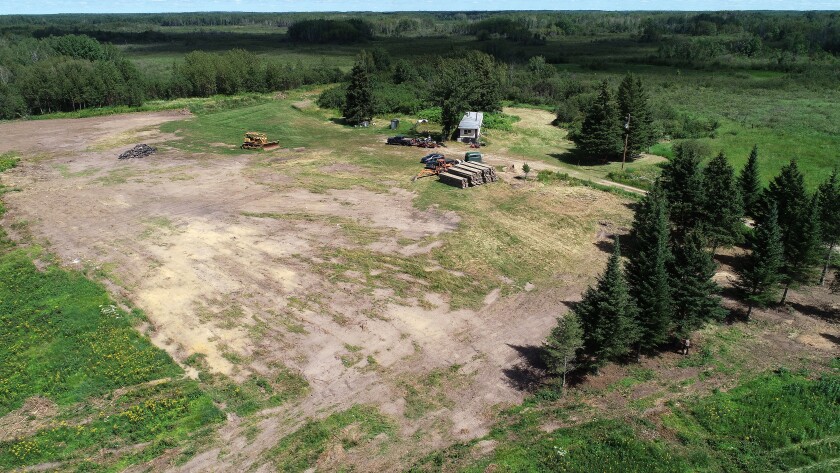 A panoramic view of the property in a large open field.