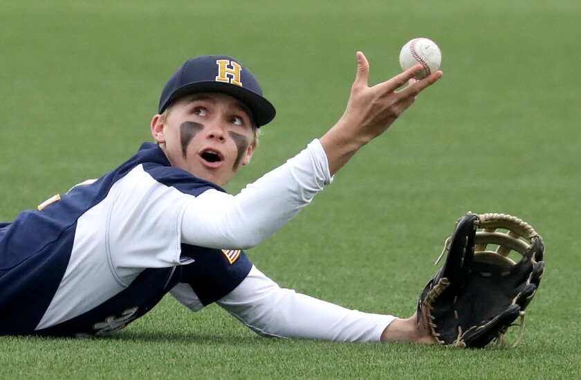 Hermantown's Wylee Arro (2) holds the ball up after making a dive catch in the outfield