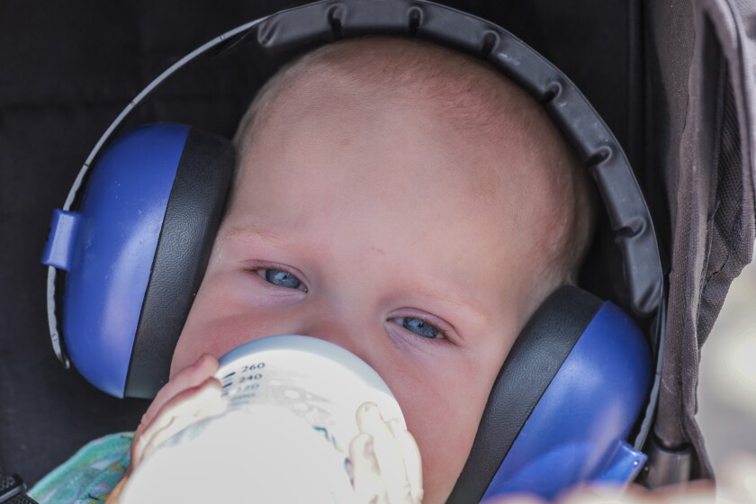 baby with headphones and bottle