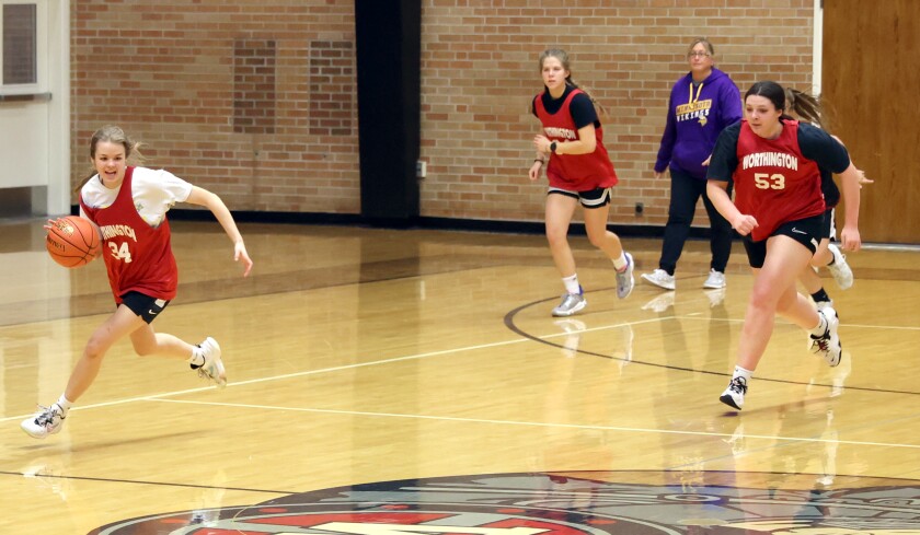 Trojans head coach Jessica Hogan watches as Regan Schaefer (24) leads a fast break drill followed by teammates Karissa Bickett and Aisha Zeida (53) during a Tuesday afternoon basketball practice.
