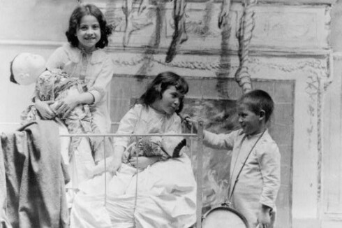 Christmas morning in about 1900, with a mantle in background where Christmas stockings have been hung. Library of Congress.jpg