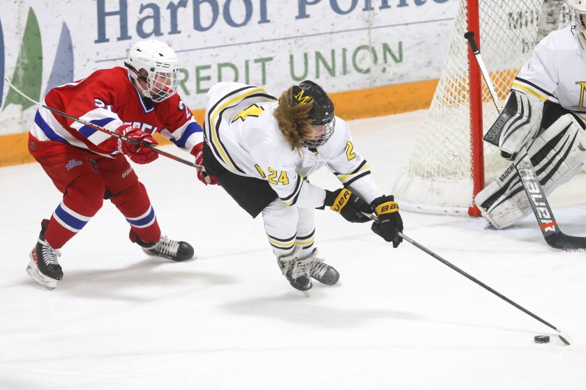 Girls hockey players in red, white and blue uniforms compete against players in black yellow and white uniforms on an indoor ice sheet.