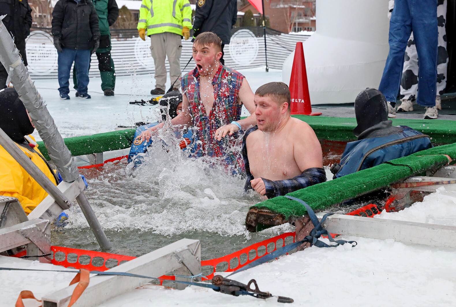 People jump into the water during the Polar Plunge event on Pelican Lake.