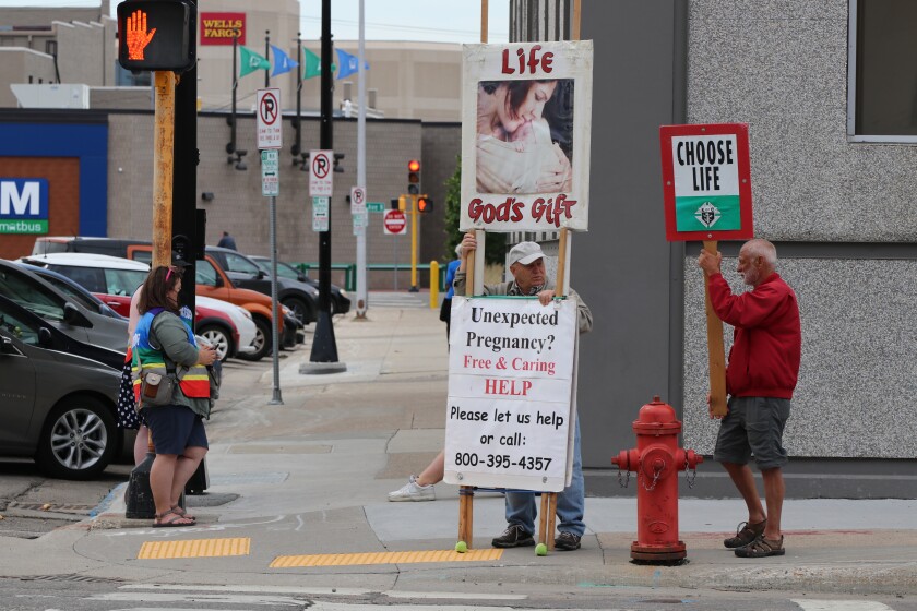 Protesters and patient escorts on the sidewalk near the Red River Women's Clinic on Wednesday, June 29, 2022.jpg