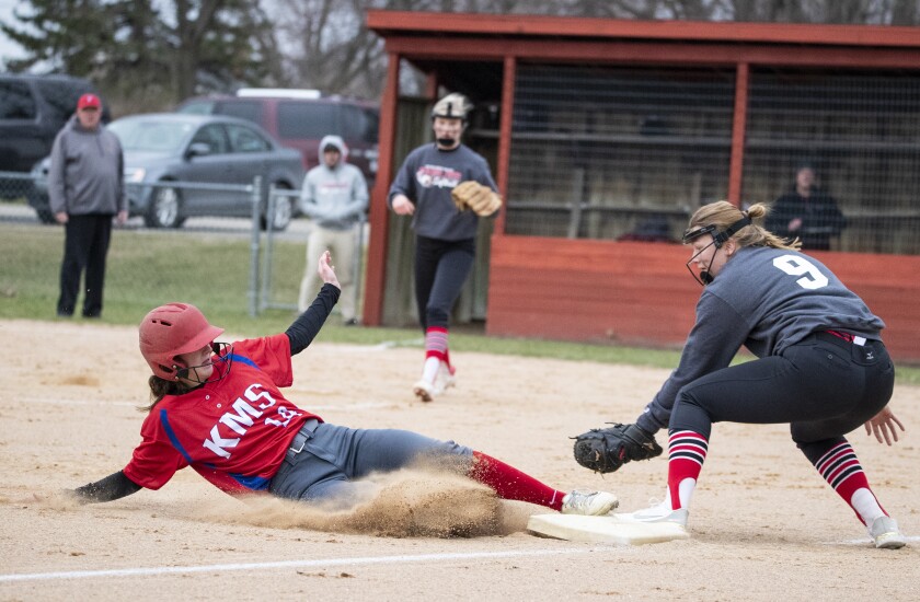 Shakira Olson of KMS avoids third baseman Tori Bungarden as she slides into the base during a game in Murdock on Thursday, April 28, 2022.