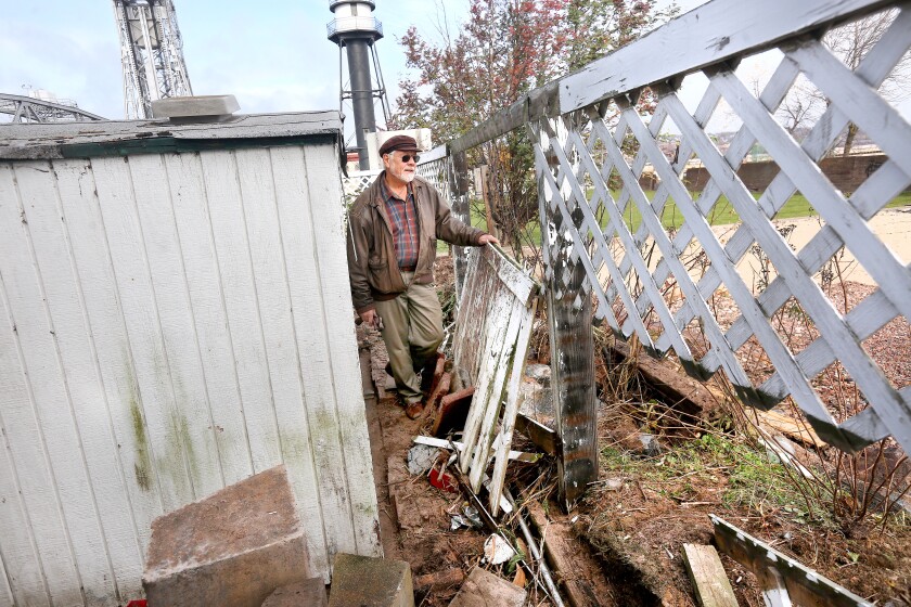 Bob Ouellette, who lives on Park Point next to the Aerial Lift Bridge, on Monday assesses the damage to his wood lattice fence and shed from wind and waves during last Friday's storm. Bob King / rking@duluthnews.com
