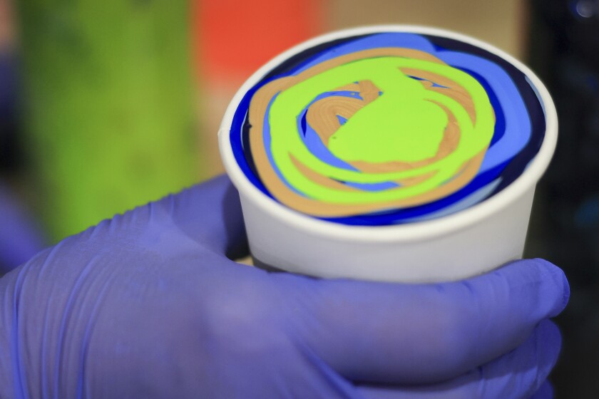 woman create fuid art work using paint