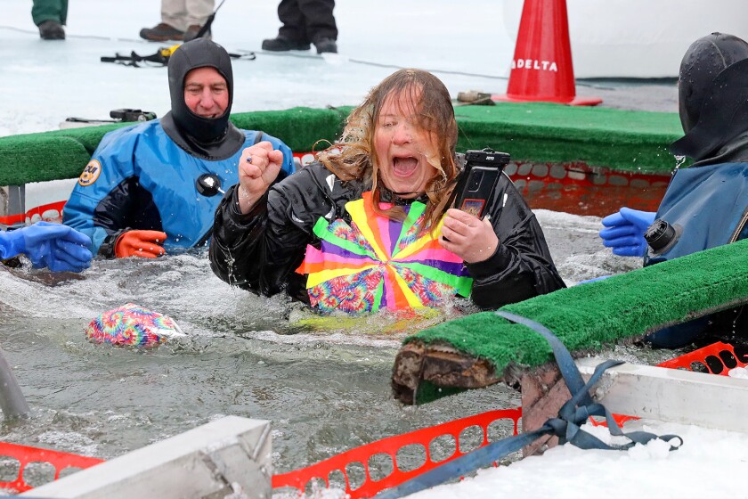 People jump into the water during the Polar Plunge event on Pelican Lake.