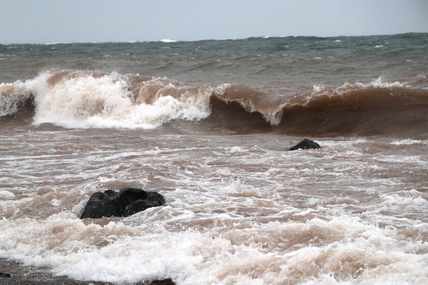 Waves crash over rocks.