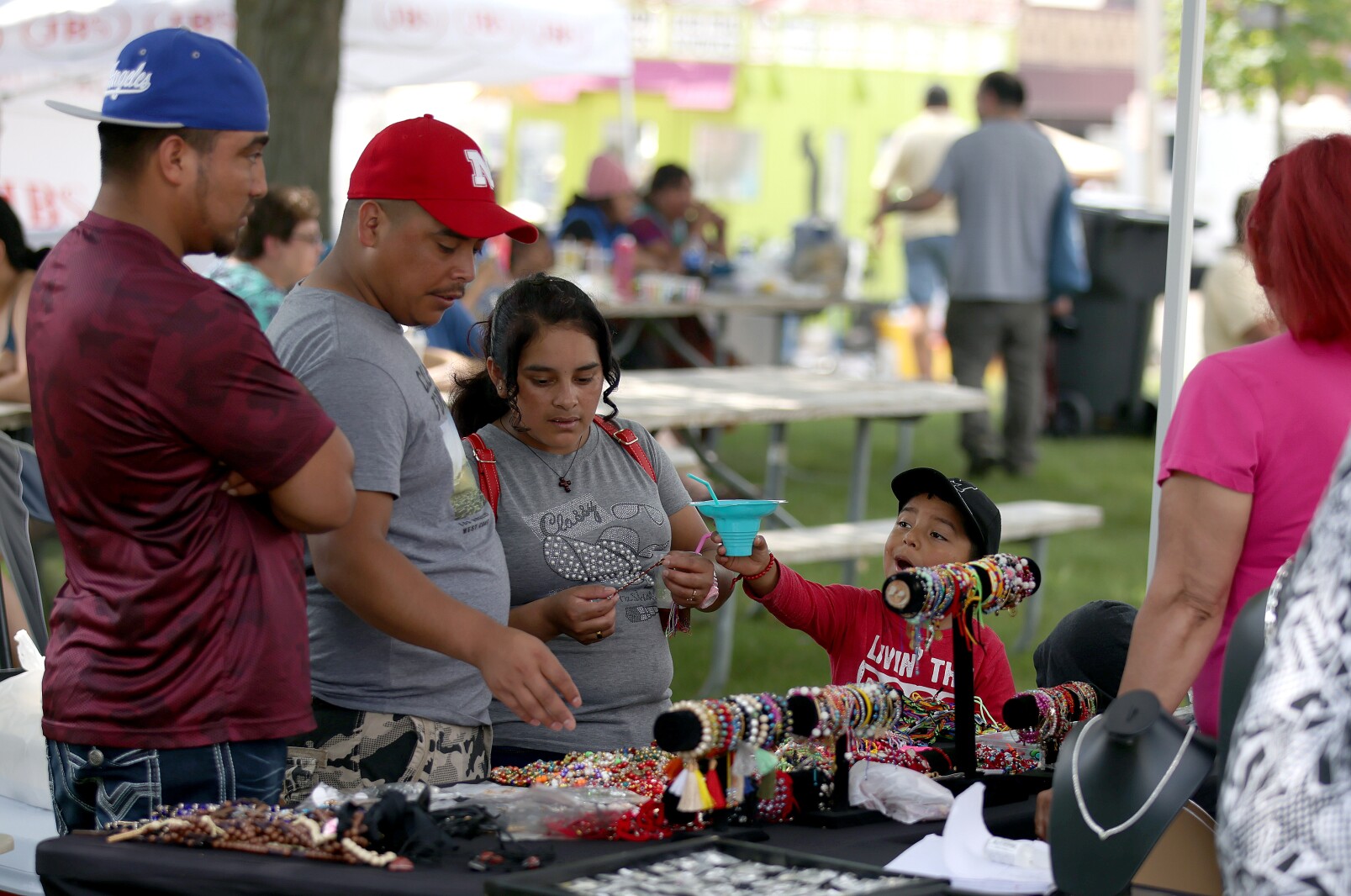 A family shops at a jewelry booth at the International Festival on Saturday, July 9, 2022.