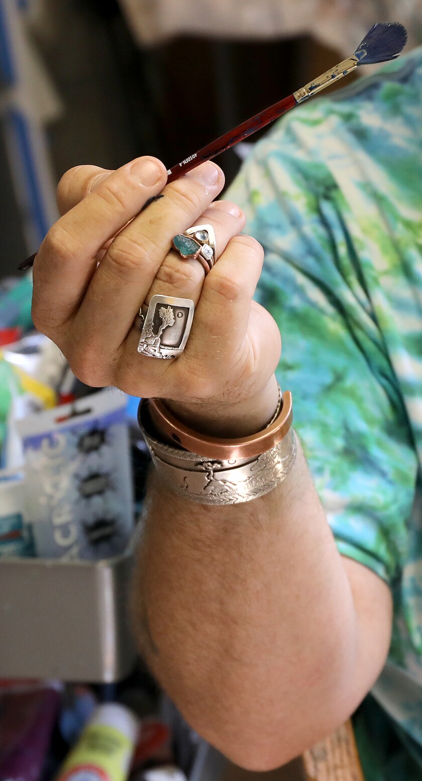 Artist Sam Zimmerman holds a paintbrush while he talks about living in New York City