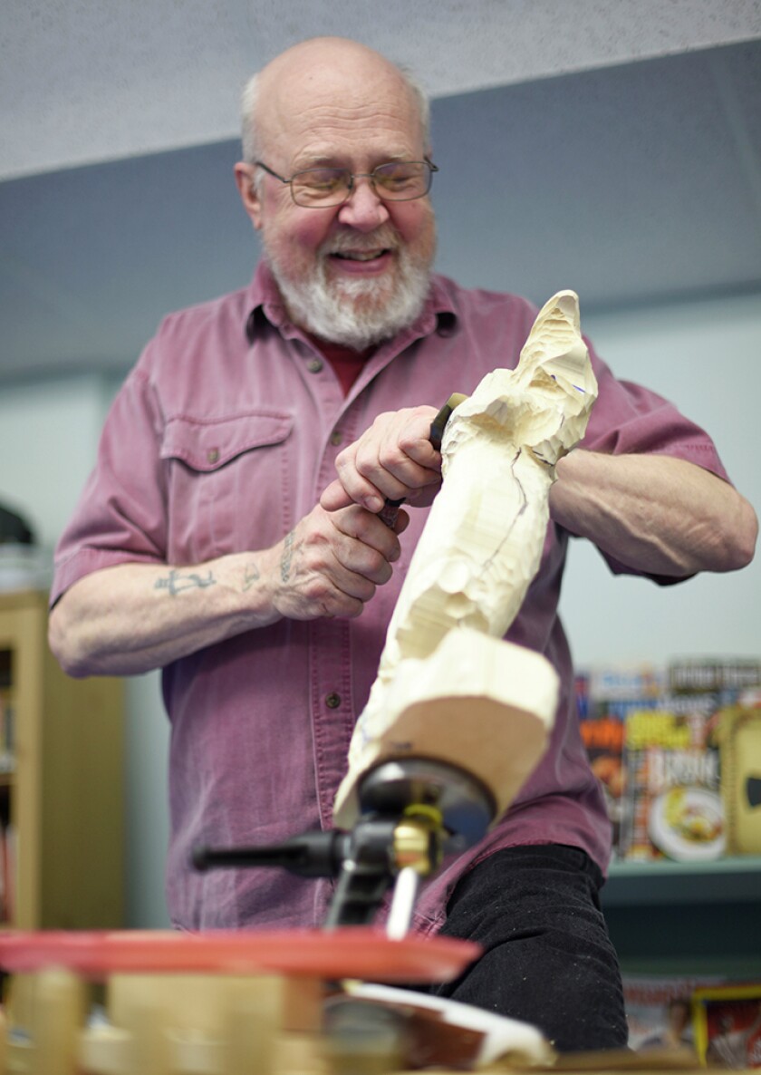 Bob Larson, of Bemidji, works on a mermaid carving during a workshop in April at the Senior Activity Center. (Jillian Gandsey | Bemidji Pioneer)